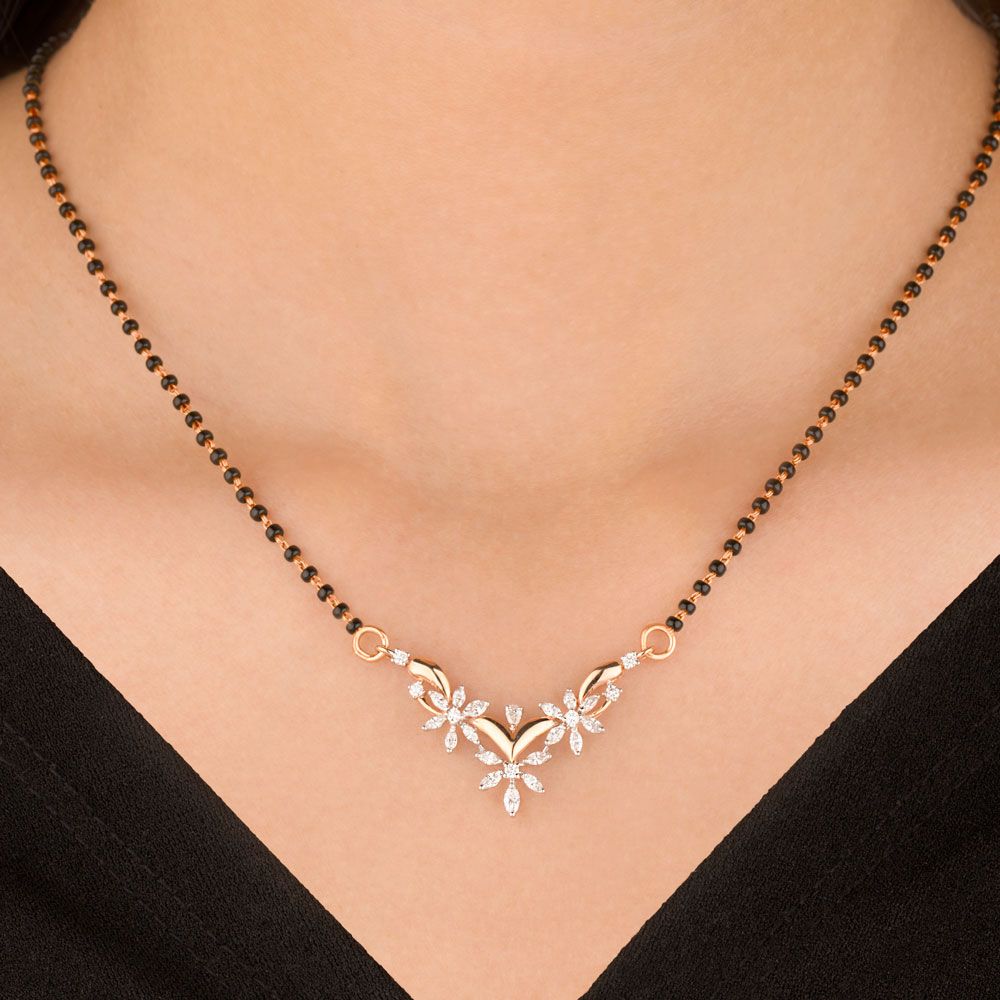 features a delicate gold chain interspersed with black beads